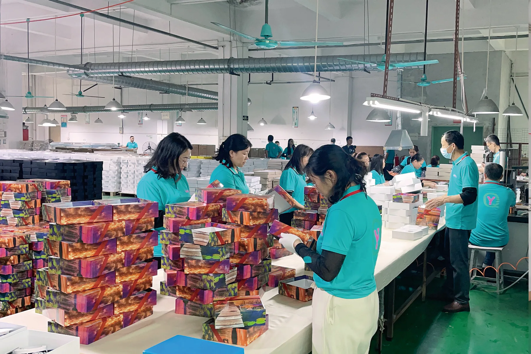 Company-supplied paper-product assembly and packing scene showing visible work only